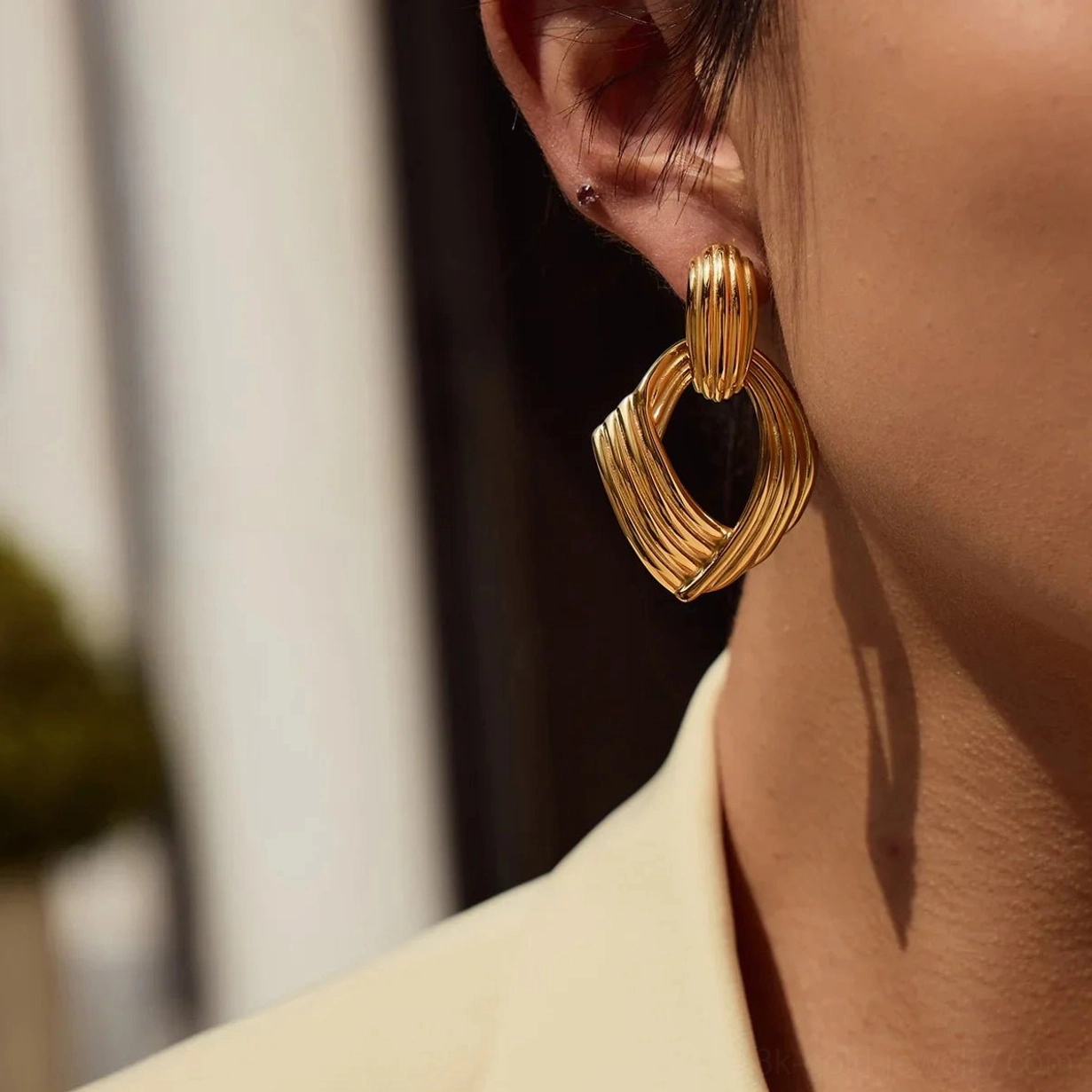 18K gold twisted drop earrings ear-worn close-up model soft lighting slim fit polished texture