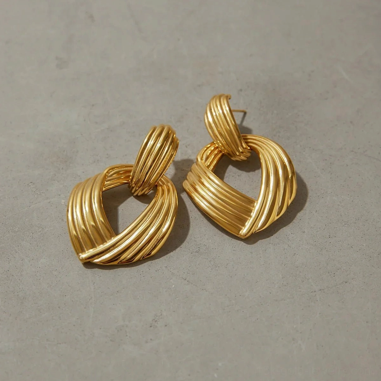 18K gold twisted drop earrings front flat product display stud post fastening ribbed details