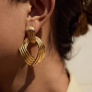 18K gold twisted drop earrings close-up on ear model side view chunky ribbed design polished finish