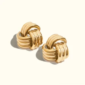 18K gold twisted knot stud earrings on plain background - flat lay product photography showing polished metal texture and dimensional knot design