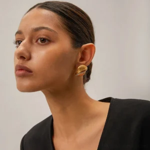 Woman wearing 18K gold twisted stud earrings with ribbed texture front portrait view