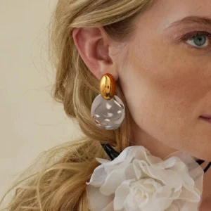 Two-tone chunky drop earrings worn on model's left ear close-up side view blonde female wearing flower choker demonstrating how earrings look when wearing