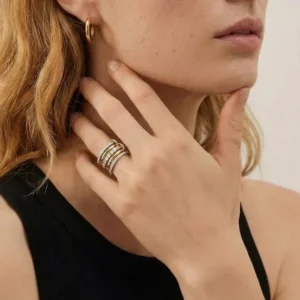 Two-tone stacked diamond ring worn on model's hand showing mixed gold and silver metal tones and diamond detailing on middle finger