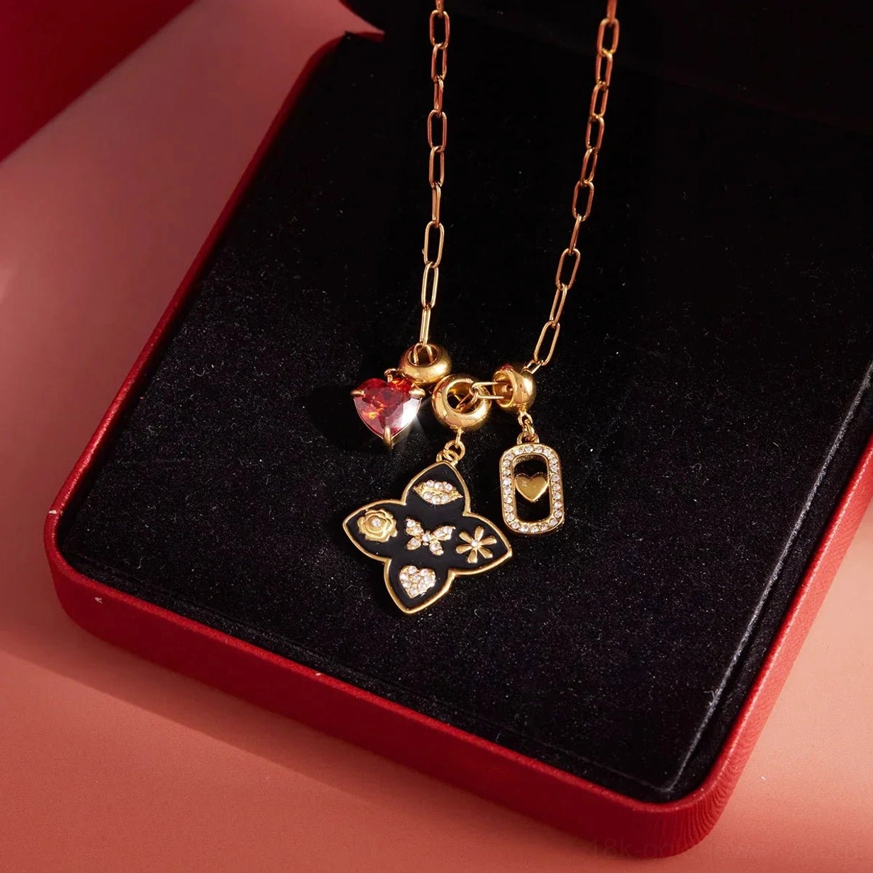 18k gold vintage charm necklace top down display view on red velvet jewelry box packaging