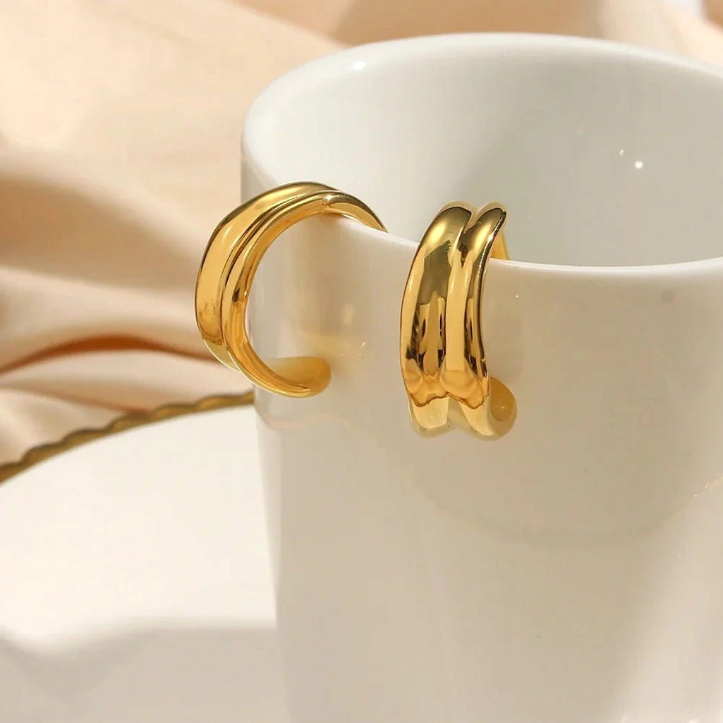 18K gold wave hoop earrings side close-up hanging on white ceramic mug lifestyle styling