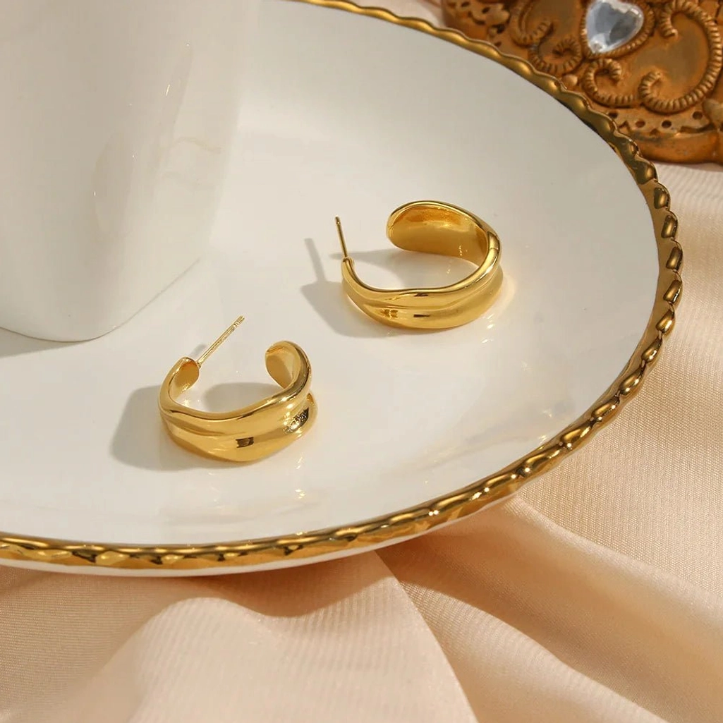 18K gold wave hoop earrings top view white ceramic gilt-edged plate product display