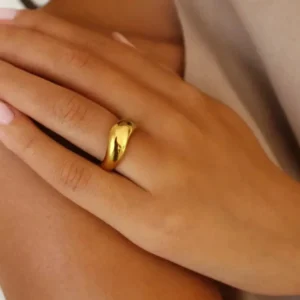 18K gold wavy band ring close-up side view worn on middle finger tanned hand elegant luxury