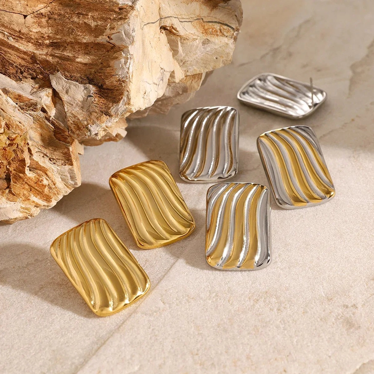 18K gold wavy rectangular stud earrings all three styles collection display stone background
