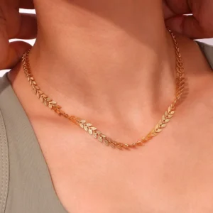 Woman wearing 18K gold wheat leaf chain necklace close-up on neck delicate leaf chain details collarbone fit