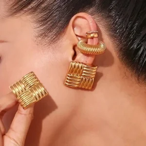 Gold woven square stud earrings close-up worn on ear side profile with dark hair model