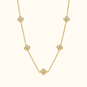 18K white gold clover station necklace with zircon crystals on neutral background, overhead flat lay view showcasing five delicate four-leaf charm details and sparkle