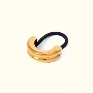 18K yellow gold double arch pony cuff hair accessory flat lay minimalist design on plain background