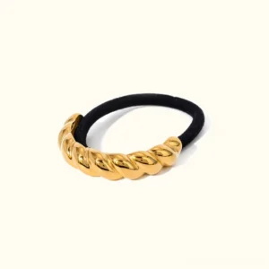 18K yellow gold twisted ponytail cuff with polished metal charm and black elastic band, top-down view