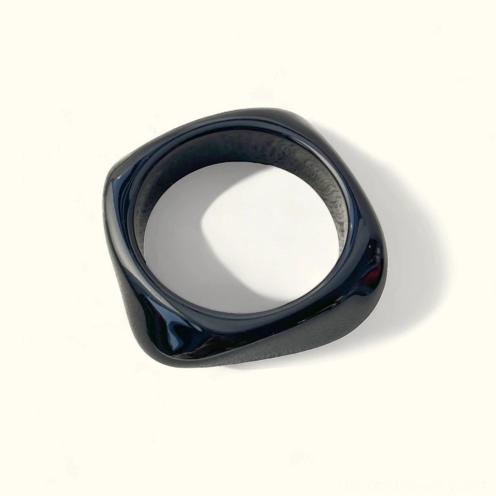 Black timeless classic solid opaque acrylic bangle bracelet with elegant finish, rounded square shape in top-down flat lay composition