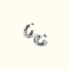 Classic silver C-hoop earrings flat lay - polished stainless steel hoop earrings top view on plain background