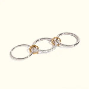 Desiree two-tone stacked diamond ring flat lay showcasing polished silver bands with gold accents and pavé CZ sparkle on white background