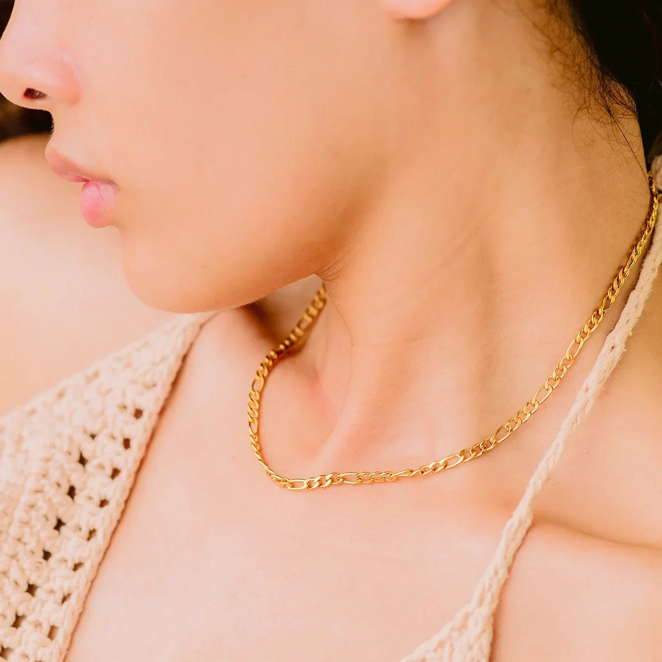 Delicate slim figaro gold chain choker necklace side view angle on model with crochet camisole styling
