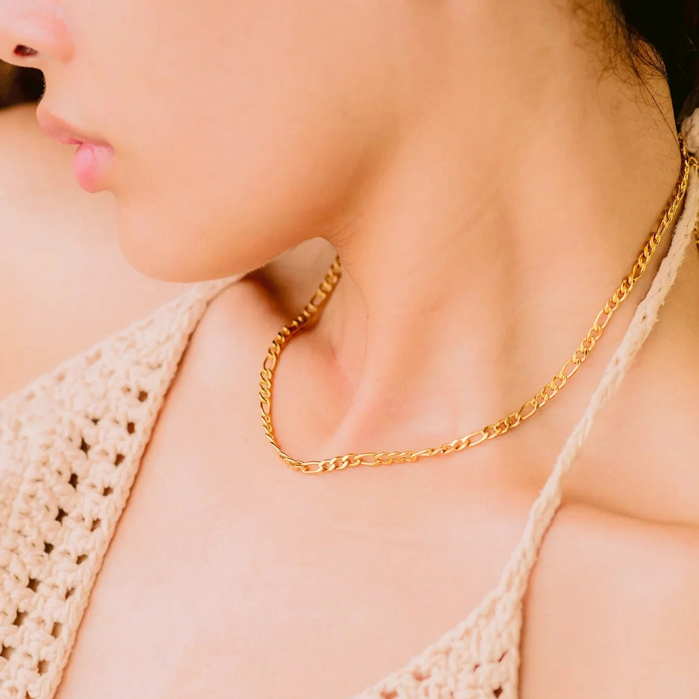 Delicate slim figaro gold chain choker necklace side view on model with crochet camisole top