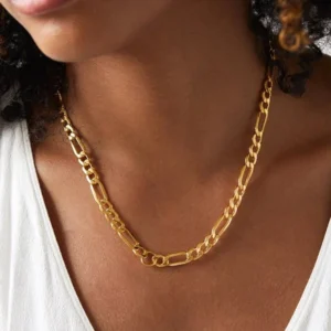 Figaro gold chain necklace worn on model neck close-up showing warm golden finish at collarbone with white top