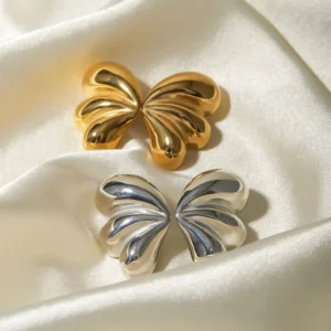 dual-tone butterfly earrings set gold and silver stud earrings on satin fabric background