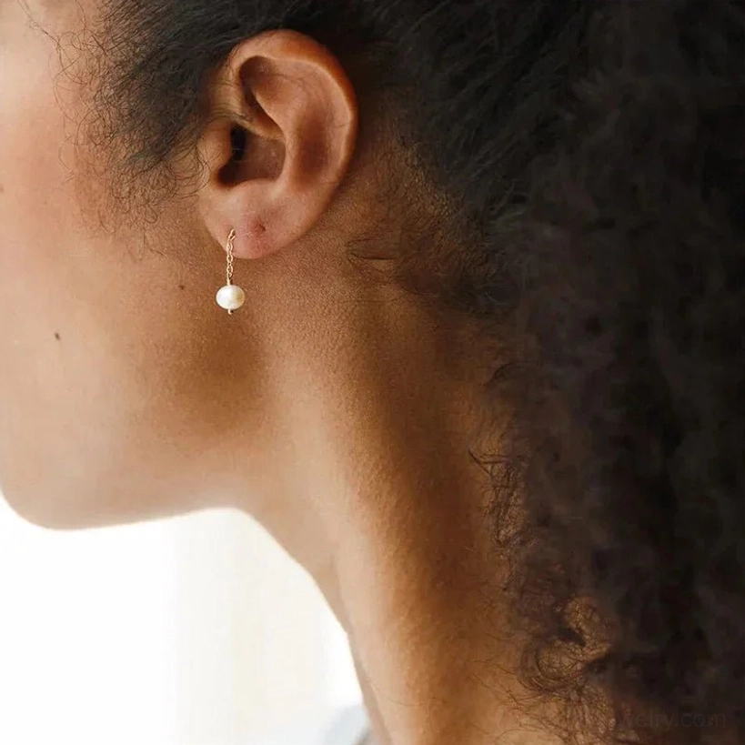 Minimalist pearl drop stud earrings back-side close-up view on female model showing sleek silhouette and single white pearl pendant