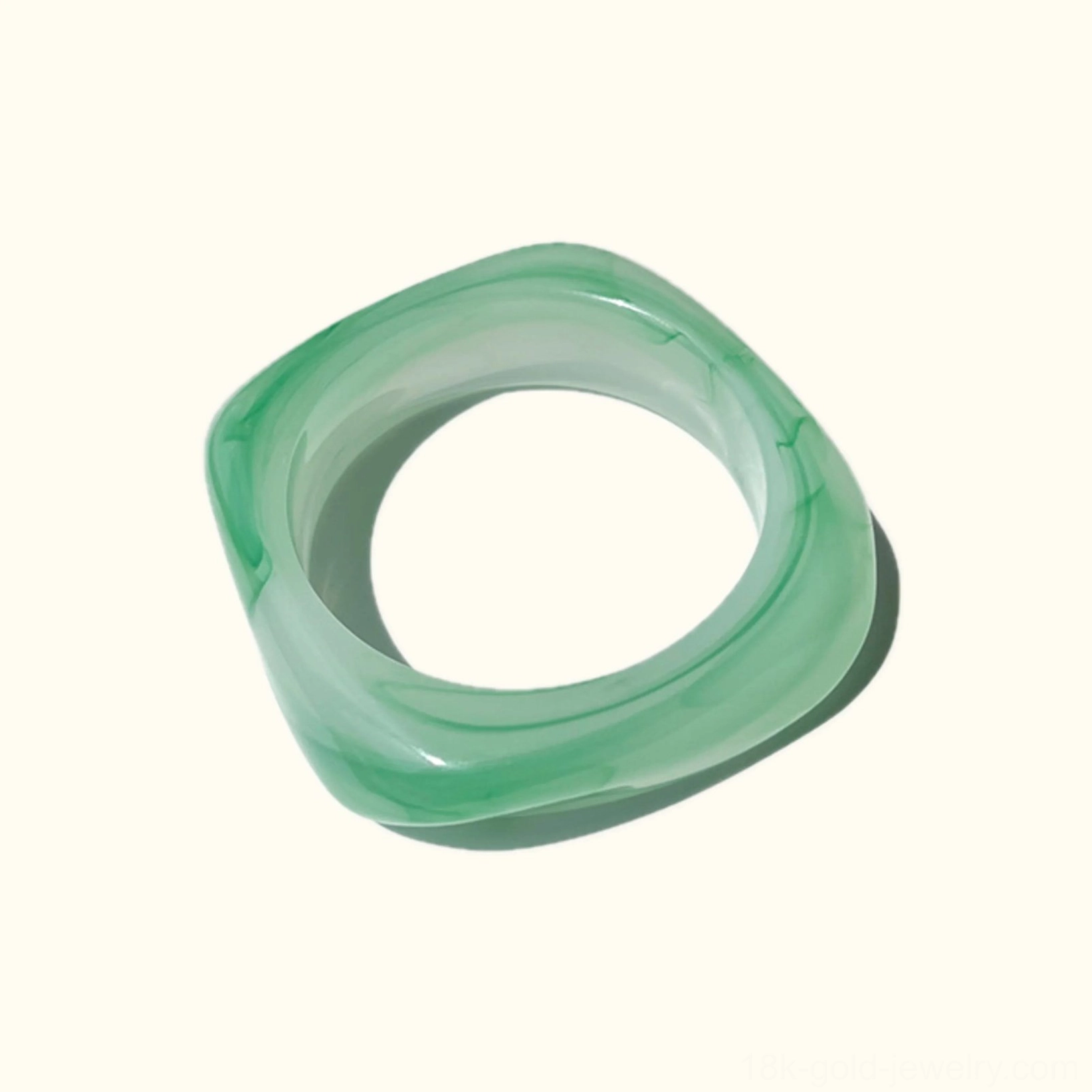 Mint Jade marbled green acrylic bangle bracelet with white veining, top-down flat lay view showcasing twisted rounded square design