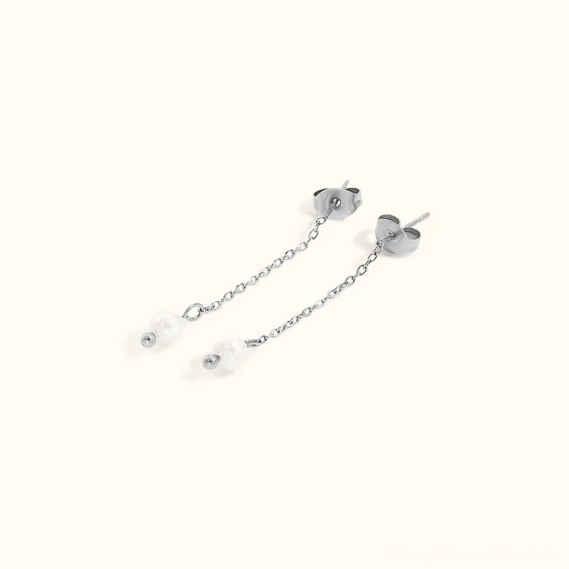 Silver-tone freshwater pearl dangle stud earrings flat lay overhead view featuring silver metal chain and heart-shaped stud backs