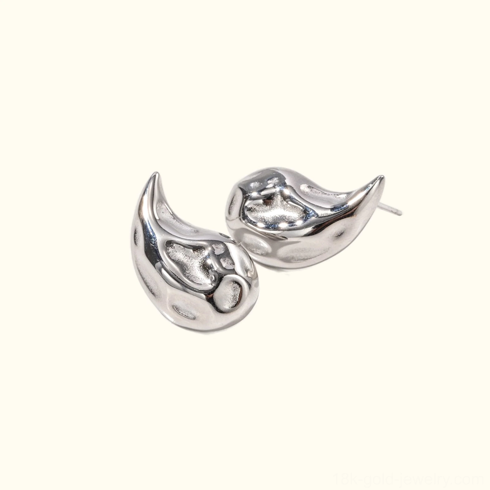 Silver teardrop stud earrings with ear post visible, flat lay front view on neutral beige background, classic polished design