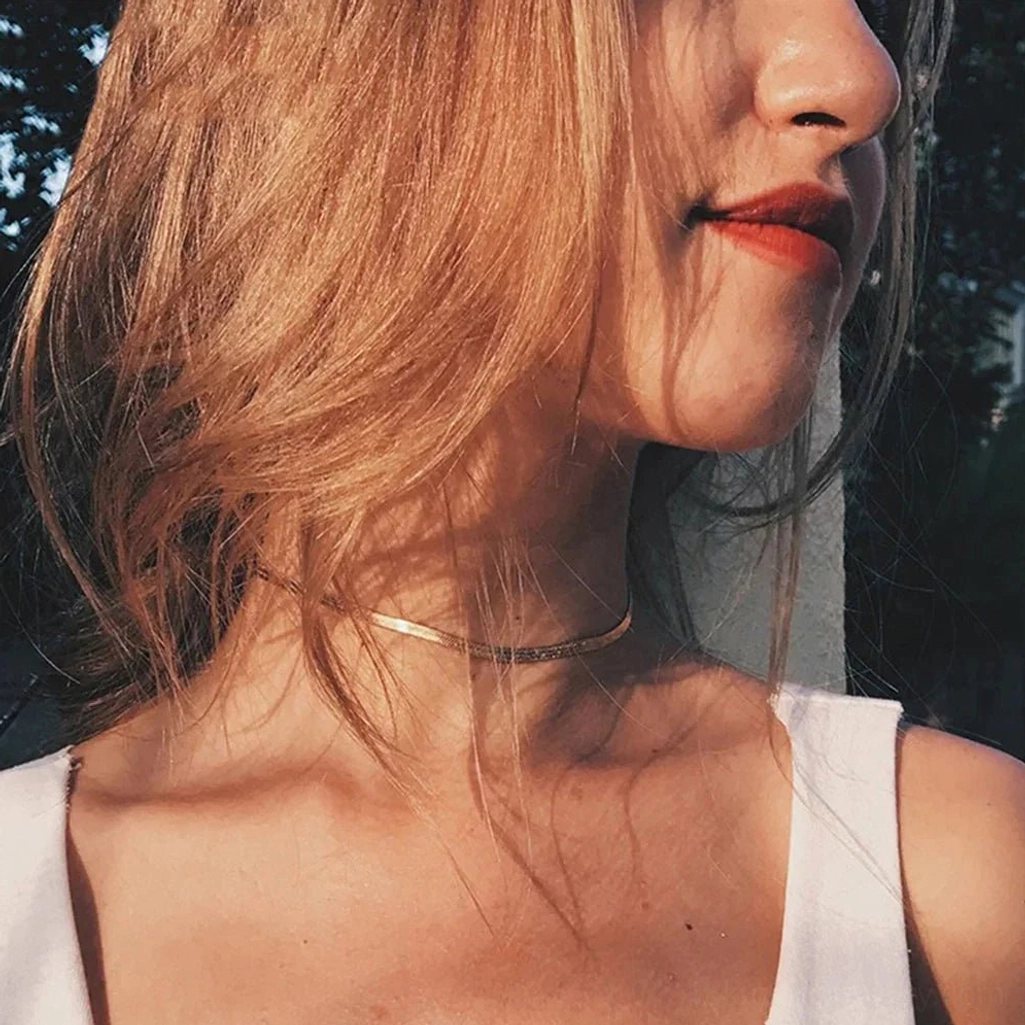 Minimalist slim gold herringbone choker necklace in close-up showing delicate 2mm chain width on model