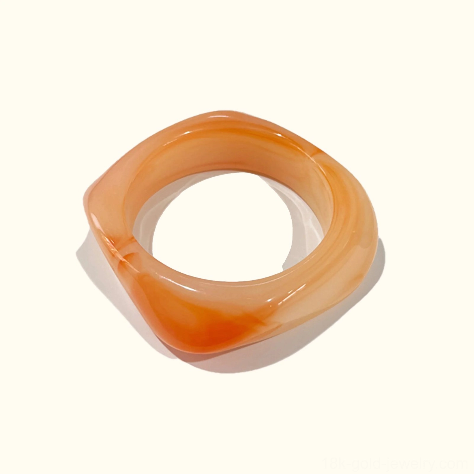 Tangerine warm citrus tone acrylic bangle bracelet with energetic vibrant coloring, rounded square design in top-down flat lay